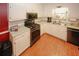 A kitchen is adorned with white cabinetry, a stainless steel oven, and sleek wood-look tile floors at 3594 Saddlebrook Dr, Loganville, GA 30052