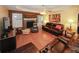 Hardwood living room featuring a stone fireplace, modern ceiling fan, and leather seating at 3594 Saddlebrook Dr, Loganville, GA 30052