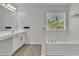 Modern bathroom featuring a soaking tub and a large window at 3610 Darcy Nw Ct, Kennesaw, GA 30144