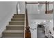 Carpeted stairs with a wooden banister lead to a view of the open-concept living area at 3610 Darcy Nw Ct, Kennesaw, GA 30144