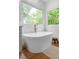 Bright bathroom featuring a freestanding soaking tub with a brushed gold faucet and natural light from two windows at 805 Ponce De Leon Ne Ter, Atlanta, GA 30306
