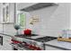 Close up of gourmet stove in kitchen with white backsplash, stainless steel hood and gray countertops at 805 Ponce De Leon Ne Ter, Atlanta, GA 30306