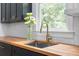 Modern kitchen featuring a butcher block countertop, stainless steel sink and elegant gold faucet at 805 Ponce De Leon Ne Ter, Atlanta, GA 30306