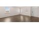 Open living room with hardwood floors, large windows, and a welcoming front door at 1950 Van Allen Ct, Dacula, GA 30019
