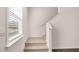 Carpeted staircase with white railing, adjacent to a bright window that brings natural light into the house at 1950 Van Allen Ct, Dacula, GA 30019