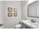 Stylish half bathroom with modern vanity, mirror, framed prints, and gray walls at 218 Jordan Dr, Woodstock, GA 30188