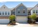 Charming two-story townhome with blue siding, a two-car garage, and neatly landscaped front yard at 218 Jordan Dr, Woodstock, GA 30188