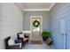 Inviting front porch with cozy chairs, a wreath on the front door, and potted plants creating a warm welcome at 218 Jordan Dr, Woodstock, GA 30188