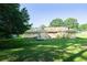 Expansive backyard featuring lush green grass, mature trees, and a stone picnic area at 2628 Hickory Trl, Snellville, GA 30078