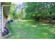 Wide, green backyard featuring a stone picnic table and mature trees, great for relaxing outdoors at 2628 Hickory Trl, Snellville, GA 30078