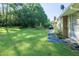 Green backyard with a stone picnic area, a grill, and plenty of open space at 2628 Hickory Trl, Snellville, GA 30078