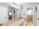 Well-lit bathroom with a granite countertop, large mirror, and a door leading to the bedroom at 2628 Hickory Trl, Snellville, GA 30078