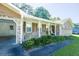 Inviting covered front porch with seating, overlooking a well-maintained yard and adjacent to a carport at 2628 Hickory Trl, Snellville, GA 30078