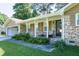 Cozy covered front porch with seating and lush landscaping, set against a classic brick facade at 2628 Hickory Trl, Snellville, GA 30078