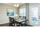 Dining room featuring a table set for four, complemented by stylish curtains and a view of the outdoor patio at 655 Blackshear Trl, Temple, GA 30179