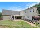 Back exterior view of the home with a covered patio and well-manicured lawn at 130 Honey Ln, Fayetteville, GA 30214