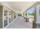 Spacious covered front porch featuring stone support columns, ceiling fans and multiple entry doors at 130 Honey Ln, Fayetteville, GA 30214