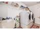 Bright laundry room featuring a washer, dryer, sink and plenty of storage at 130 Honey Ln, Fayetteville, GA 30214