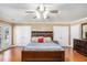 Spacious primary bedroom featuring hardwood floors, fan and neutral paint at 130 Honey Ln, Fayetteville, GA 30214
