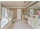 Bright bathroom featuring a soaking tub, shower, double vanity, and decorative mirror at 4213 Bretdale Nw Run, Kennesaw, GA 30152