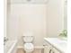 Bright bathroom featuring a toilet, shower and vanity with a white sink at 4213 Bretdale Nw Run, Kennesaw, GA 30152