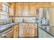 A well-lit kitchen with stainless steel appliances and wooden cabinets with dark countertops by the window at 4213 Bretdale Nw Run, Kennesaw, GA 30152