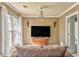 Cozy living room featuring a decorative chandelier, large window, and warm wall color at 4213 Bretdale Nw Run, Kennesaw, GA 30152