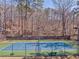Beautifully maintained community tennis court with net and benches is surrounded by lush greenery at 4213 Bretdale Nw Run, Kennesaw, GA 30152