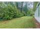 Backyard of the home with green grass and landscaping with green vinyl siding at 4244 Dorsey Sw Ct, Lilburn, GA 30047