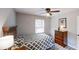 This is a cozy bedroom featuring a ceiling fan, window, and a wooden dresser at 4244 Dorsey Sw Ct, Lilburn, GA 30047