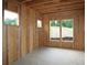 Unfinished bedroom with exposed wood framing, concrete floor, and natural light from the yard at 4740 Briscoe Drive, Cumming, GA 30028