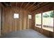 Unfinished bedroom with exposed wood framing, concrete floor, and natural light from the yard at 4740 Briscoe Drive, Cumming, GA 30028