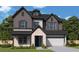 Charming two-story home featuring stone accents, vertical siding, a black roof, and a two-car garage at 4740 Briscoe Drive, Cumming, GA 30028