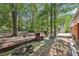 Landscaped backyard featuring a brick firepit, mature trees, and a partially visible pool area at 5222 Skyline Dr, Stone Mountain, GA 30083
