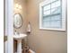 Charming powder room featuring a pedestal sink, a window, and neutral tones for a serene atmosphere at 59 Creekside Blf, Hiram, GA 30141
