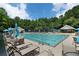 Large community swimming pool with lounge chairs, umbrellas, and a bath house surrounded by lush greenery at 59 Creekside Blf, Hiram, GA 30141