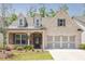 Charming brick home featuring a welcoming porch, manicured lawn, and a two-car garage at 1409 Bluffs Ridge Way, Canton, GA 30114