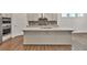 Modern kitchen island featuring a sink, countertop seating, and stainless steel appliances at 1409 Bluffs Ridge Way, Canton, GA 30114