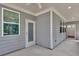Covered patio with gray siding features an entrance door and window at 1409 Bluffs Ridge Way, Canton, GA 30114