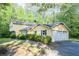 Two-story house with an attached garage and a driveway, surrounded by trees and greenery at 2037 Cliffton Ter, Snellville, GA 30039