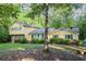 View of yellow, two-story home with well-kept lawn and mature trees offering shade and privacy at 2037 Cliffton Ter, Snellville, GA 30039