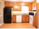 Kitchen features wooden cabinets, granite countertops, white appliances, and hardwood flooring at 2037 Cliffton Ter, Snellville, GA 30039