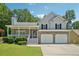 Charming two-story home featuring a covered porch, stone accents, and an attached two-car garage at 3705 Tate Pl, Austell, GA 30106