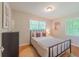Light-filled bedroom with a bed, wooden floors, dresser, and neutral wall colors at 4236 Beaver Ruin Nw Ct, Lilburn, GA 30047