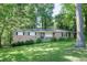 Charming single-story brick home nestled among mature trees and a lush, green lawn at 4236 Beaver Ruin Nw Ct, Lilburn, GA 30047
