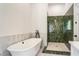 Modern bathroom with a freestanding tub, walk-in shower with green tiling, and marble accents at 481 Glenwood Se Ave, Atlanta, GA 30312