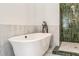 Modern bathroom with freestanding tub, decorative fixtures, and walk-in shower with green tiled walls at 481 Glenwood Se Ave, Atlanta, GA 30312