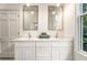 Bathroom vanity with double sinks, white cabinets, and green towels, complemented by natural light from the window at 481 Glenwood Se Ave, Atlanta, GA 30312