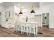 Stylish white kitchen featuring a marble island with seating, pendant lighting, and stainless steel appliances at 481 Glenwood Se Ave, Atlanta, GA 30312