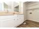 Bright bathroom featuring double sinks, white cabinets, and laundry area with shelving for ample storage at 5243 Valleyview Dr, Acworth, GA 30102